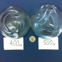 400 cc and 500 cc breast implants compared to the size of a quarter.